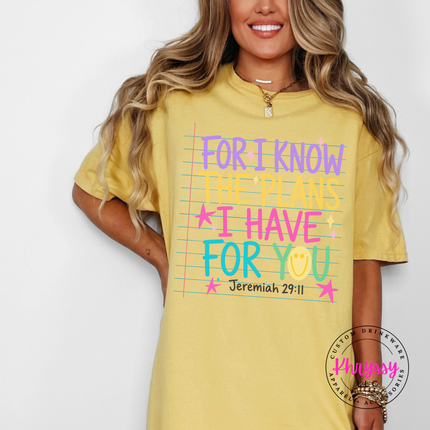 Woman wearing a Mustard tee with the colorful for I know the plans verse