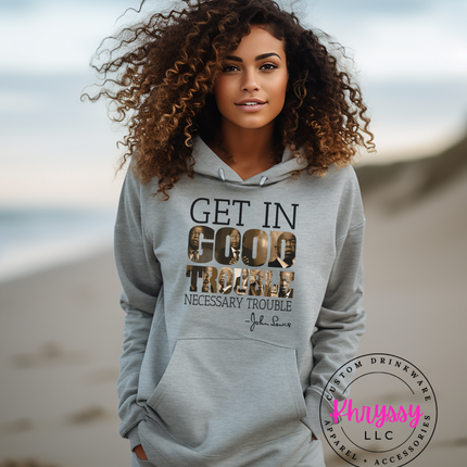 Woman wearing a "Get in Good Trouble" inspirational quote hoodie on a beach