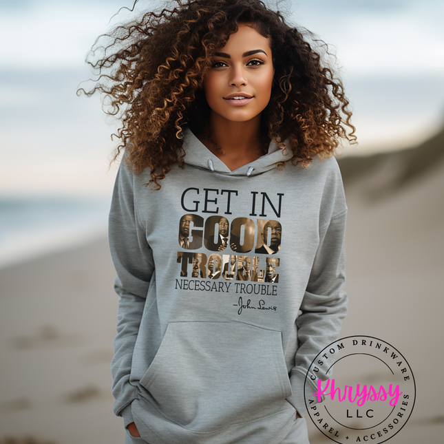 Woman wearing a "Get in Good Trouble" inspirational quote hoodie on a beach