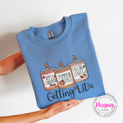 Carolina Blue crewneck sweatshirt with the Getting Lit fall candles graphic