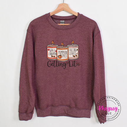 Heather dark maroon crewneck sweatshirt featuring three fall candles illustration.