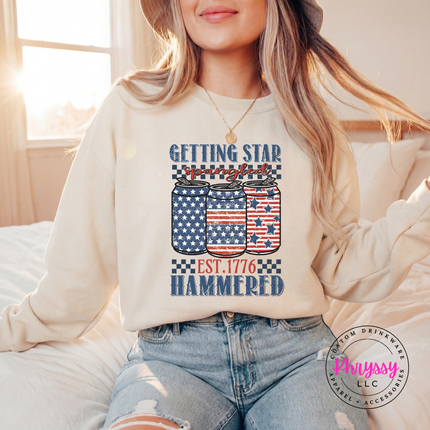 Sand crewneck sweatshirt displaying a vintage patriotic beer-can graphic with white stars.