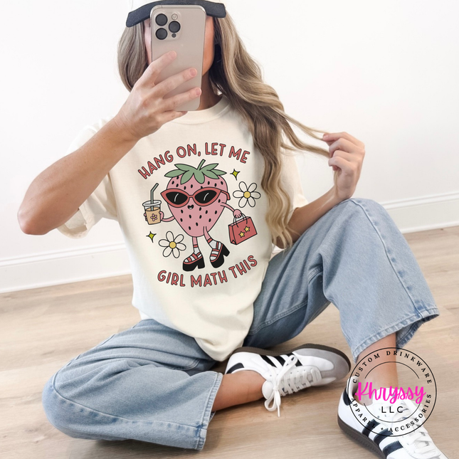 Close-up of the strawberry character with sunglasses on an Ivory colored tee.
