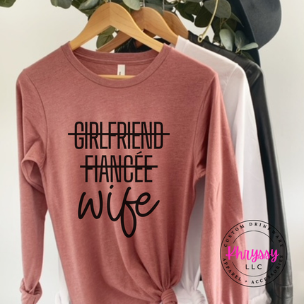 Pink t-shirt with 'Girlfriend Fiancée Wife' text on a hanger