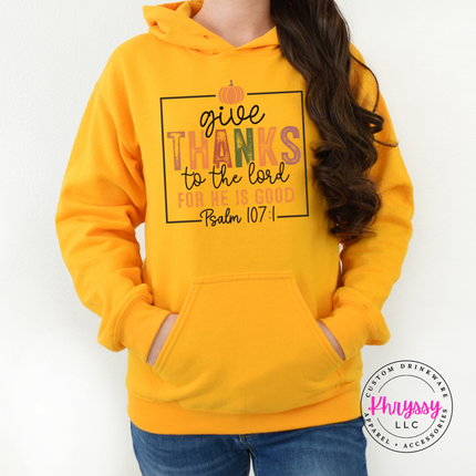 Gold hoodie with kangaroo pocket showing a Give Thanks To The Lord verse print.