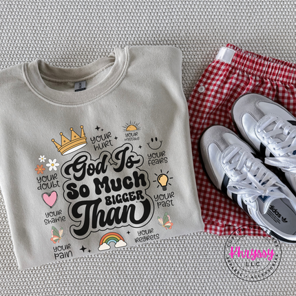 Sand crewneck sweatshirt displaying a God Is So Much Bigger Than faith design.