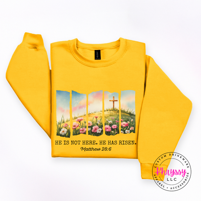 Gold crewneck sweatshirt featuring a watercolor He Has Risen Easter design.