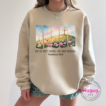 Sand crewneck sweatshirt displaying a He Has Risen cross and wildflowers design.