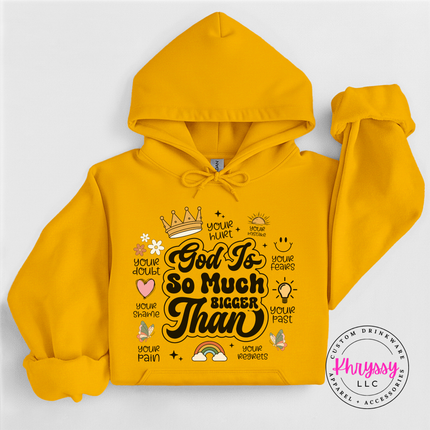Gold pullover hoodie with an encouraging God Is So Much Bigger Than graphic.