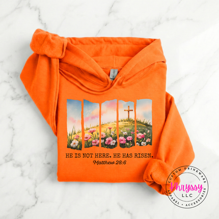 Orange pullover hoodie with a watercolor Easter He Has Risen graphic and verse.