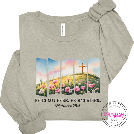 Sand Dune long sleeve tee with a watercolor Easter He Has Risen graphic and verse.