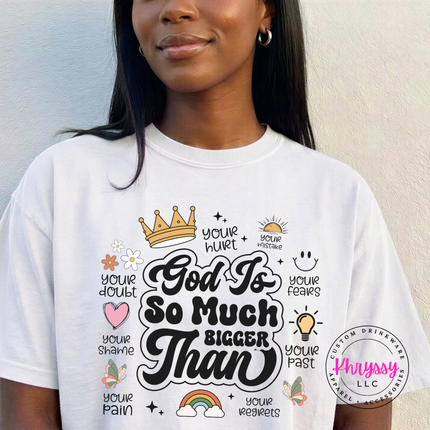 White garment-dyed tee displaying a God Is So Much Bigger Than faith design.