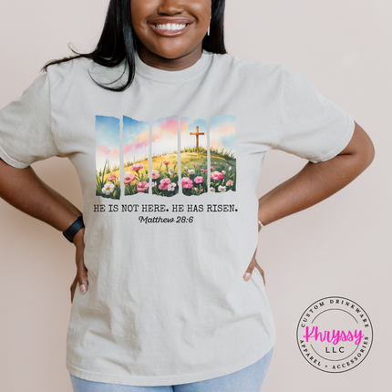 Sandstone garment-dyed tee displaying a He Has Risen cross and wildflowers design.