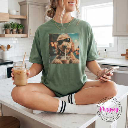 Woman sitting on a kitchen counter holding a drink and phone, wearing a green t-shirt with a dog graphic.