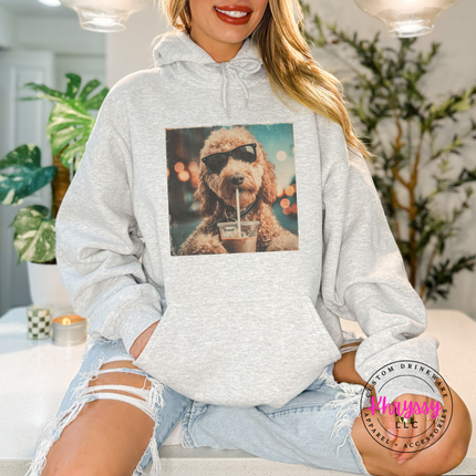 Person wearing a gray hoodie with a dog graphic, sitting indoors.