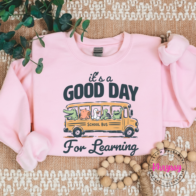 Light pink crewneck with duck, frog, and groundhog bus design.