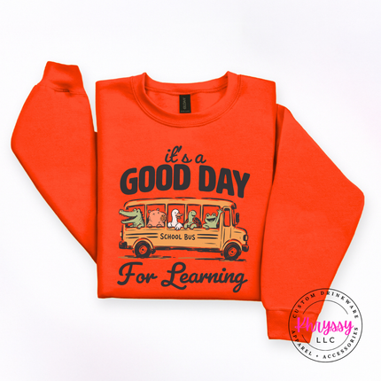 Orange Gildan crewneck featuring Good Day For Learning graphic.
