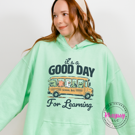 Mint green hoodie with turtle, frog, and groundhog bus design.