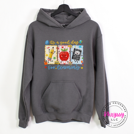 Charcoal hoodie with cheerful classroom pencil and notebook illustration.