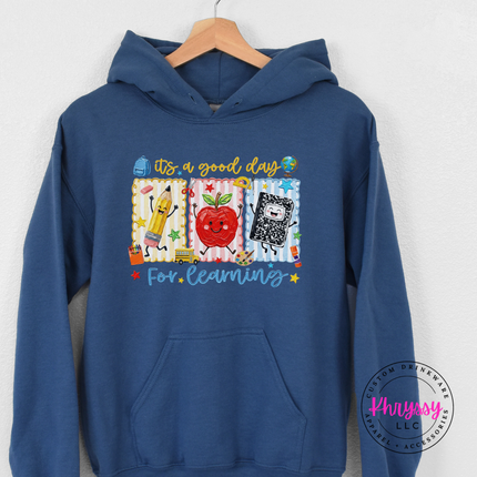 Indigo brushed-fleece hoodie with colorful pencil, apple, and notebook design.
