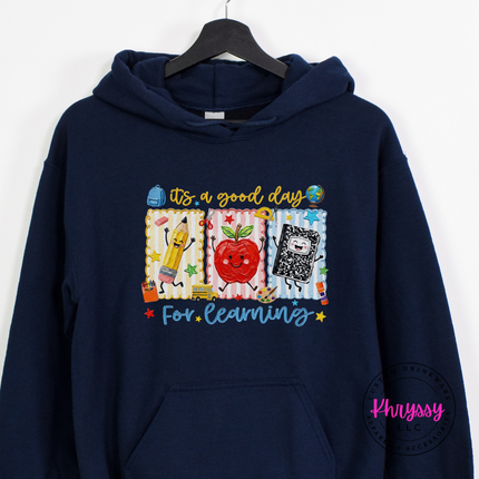 Navy blue hoodie with cheerful classroom pencil and notebook illustration.