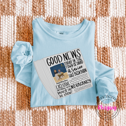 Ice Blue long sleeve tee featuring a vintage Good News nativity newspaper.