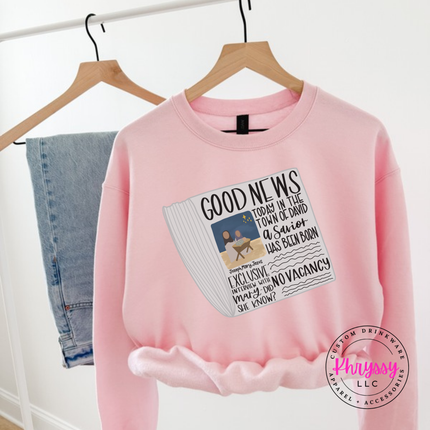 Model wearing the Good News nativity crewneck sweatshirt in Light Pink.