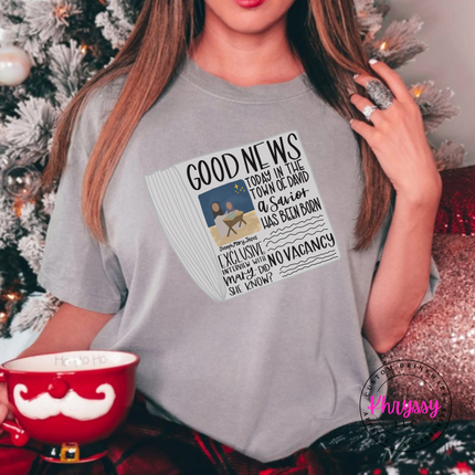 Flat lay of the Good News nativity Christmas tee in Gray.