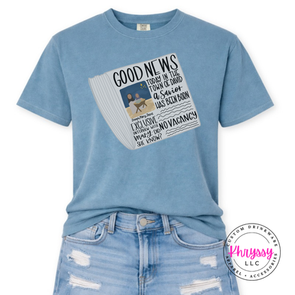 Washed Denim tee showing a Good News newspaper with a nativity photo.