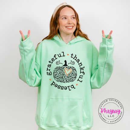 Woman wearing an Mint pullover hoodie with a leopard pumpkin design.