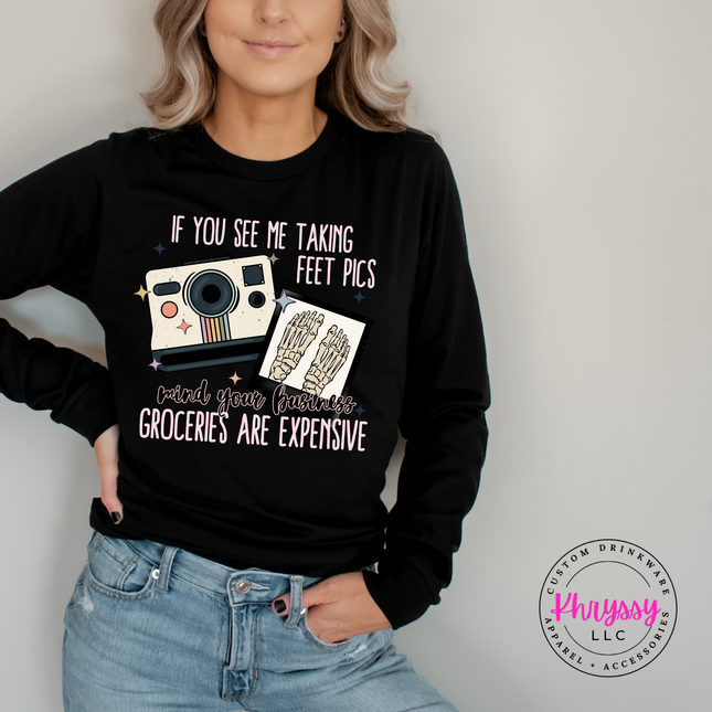 Person wearing a black sweatshirt with a graphic and text, standing against a plain background.
