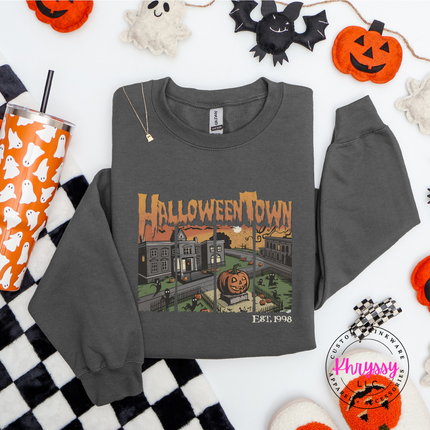 Woman wearing a Charcoal crewneck sweatshirt with a Halloweentown spooky graphic.