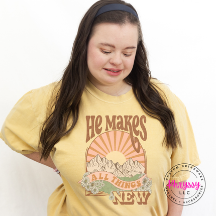 Butter garment-dyed tee with a retro sunset and He Makes All Things New design.