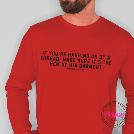 Red long sleeve tee featuring the hanging on by a thread faith verse in white