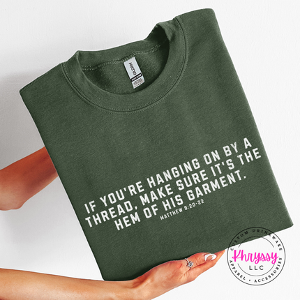 Military Green crewneck sweatshirt printed with the hem of His garment verse in white
