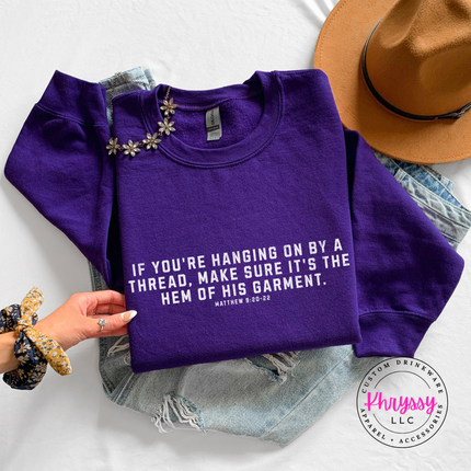 Purple crewneck sweatshirt showing the hem of His garment scripture in white
