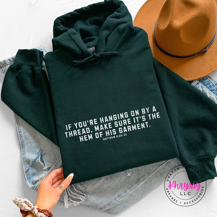 Forest hoodie showing the hem of His garment scripture in white lettering
