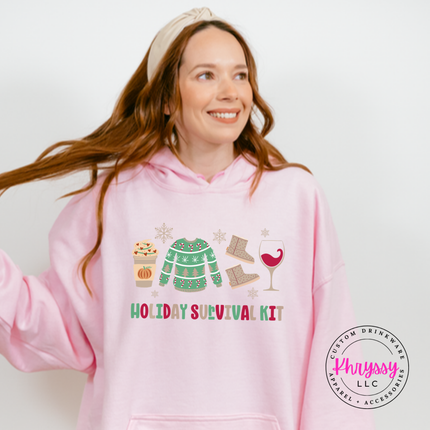 Light Pink hoodie featuring festive survival kit icons and lettering.