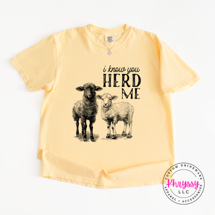 Yellow t-shirt with sheep graphic and text 'i know you HERD ME' on a white background