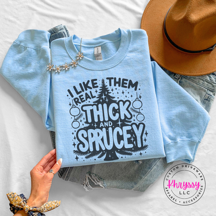 Close up of the Thick and Sprucey pun on a Light Blue crewneck sweatshirt.
