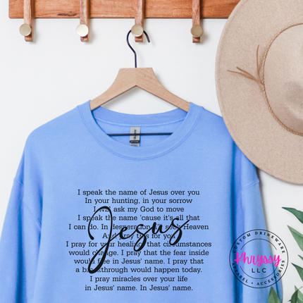 Carolina Blue crewneck showing an I Speak the Name of Jesus prayer design.