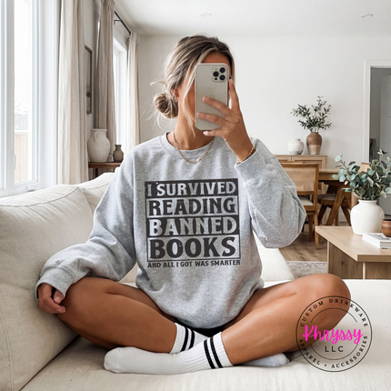 Sport Grey Gildan crewneck printed with bold distressed I Survived Reading Banned Books typography.