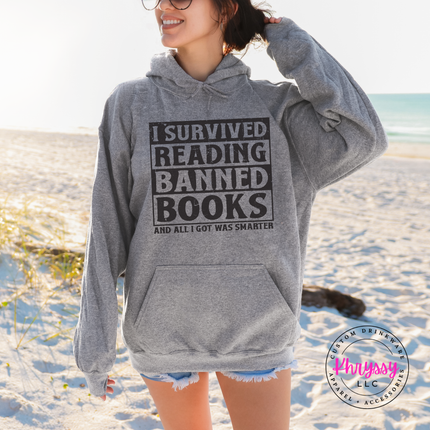 Graphite Heather Gildan hoodie printed with bold distressed I Survived Reading Banned Books typography.