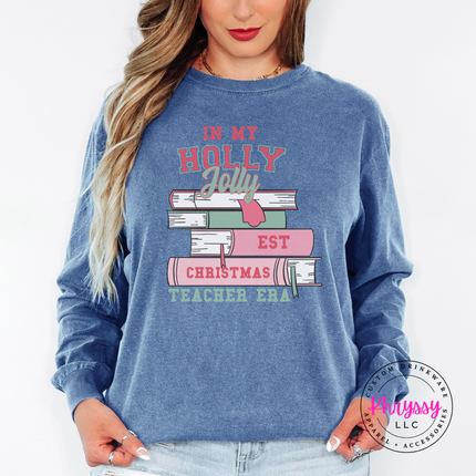 Holly Jolly Christmas Teacher Era book stack printed on a Blue Jean long sleeve tee.