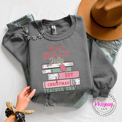 Holly Jolly Christmas Teacher Era book stack printed on a Charcoal crewneck sweatshirt.