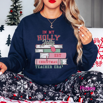 Holly Jolly Christmas Teacher Era book stack printed on a Navy crewneck sweatshirt.