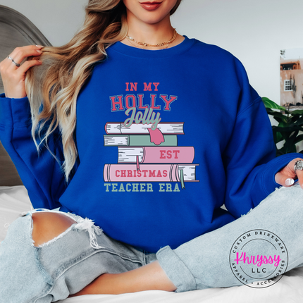 Royal crewneck sweatshirt featuring varsity lettering on a stack of books.