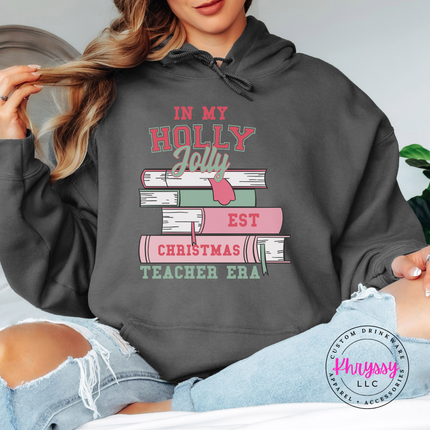 Woman wearing the Holly Jolly teacher era hoodie in Charcoal.
