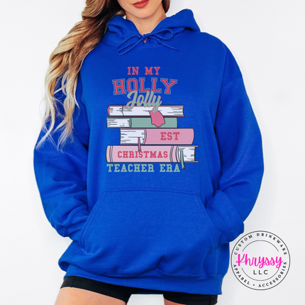 Woman wearing the Holly Jolly teacher era hoodie in Royal.

