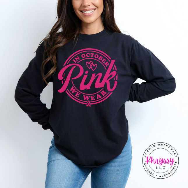 Woman wearing a Black long sleeve tee with the in October we wear pink badge
